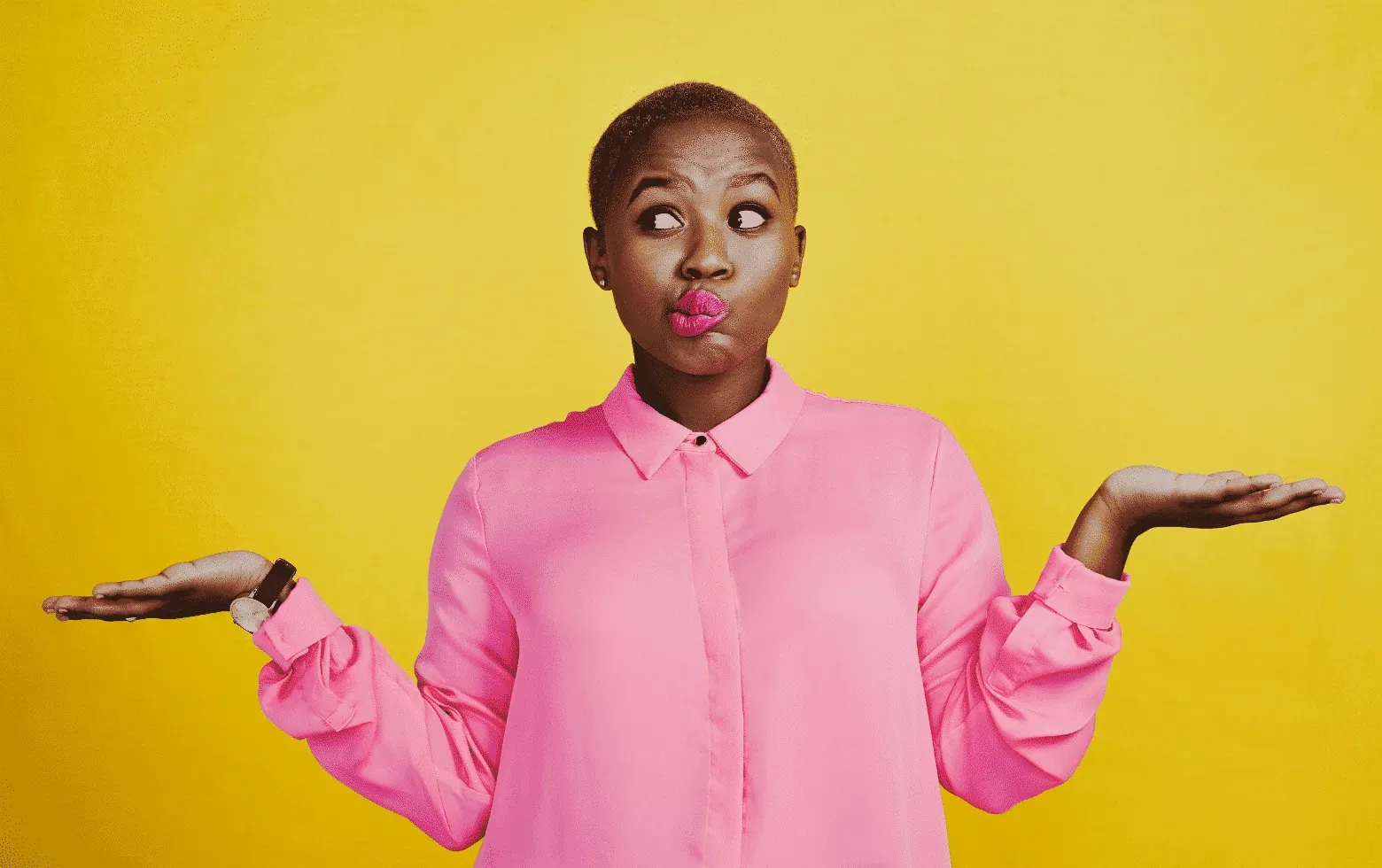Woman in a pink shirt shrugging with both palms up against a yellow background
